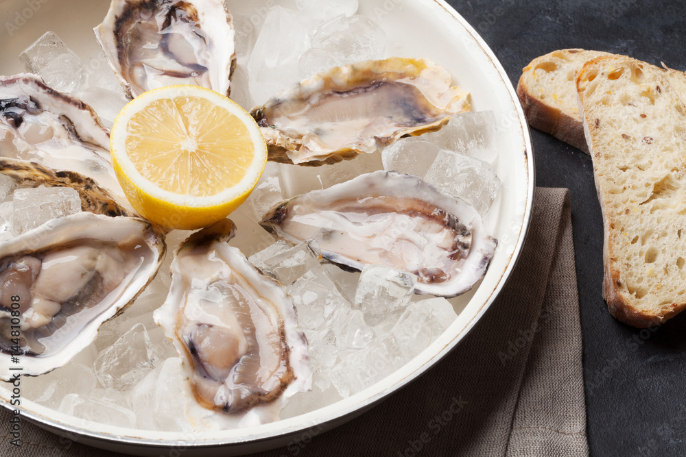 Opened oysters and lemon over ice Opened oysters and lemon over ice