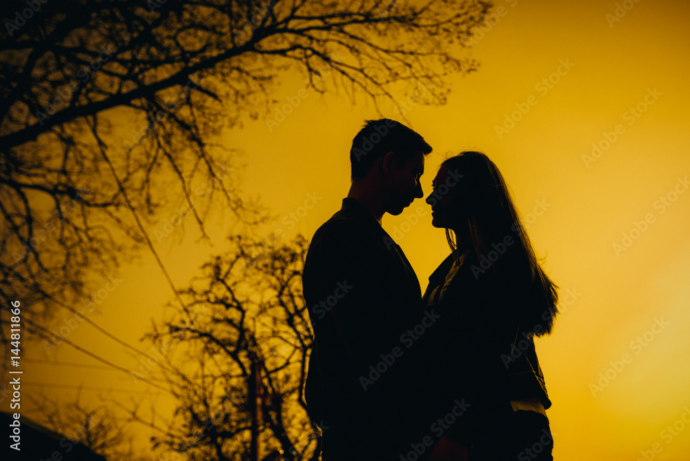 Amazing silhouette of lovers. True love emotions of joyful cute couple enjoying time together outdoor in city. Lovely happy moments, having fun, smiling in love on the background of the city.