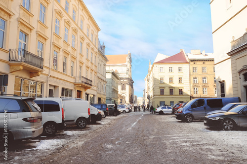 City street with old buildings and cars in winter