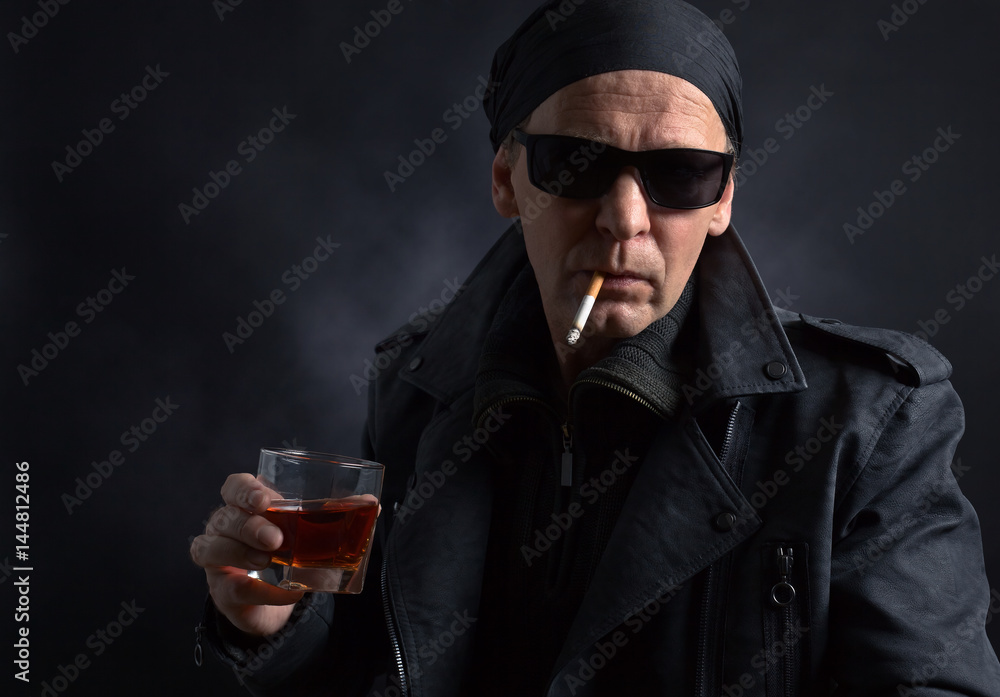 Rocker with glass of whiskey and cigarette on black background. Rocker with glass of whiskey and cigarette on black background.