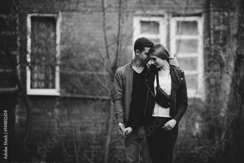 Couple has fun and laughs. kiss. Young hipster couple hugging each other in city.