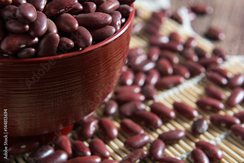 Red beans in a cup with a wooden sign on the wooden floor.