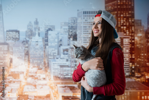 Fotografie Smiling girl with a cat in hands