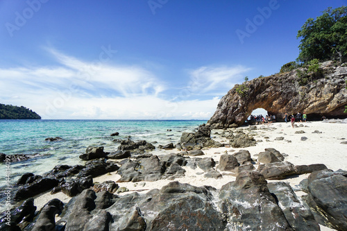 rocks with sand at coastline with bright sunlight in blue sky