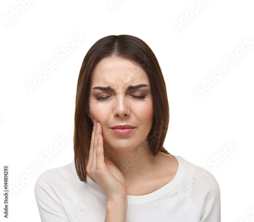 Beautiful young woman suffering from toothache on white background