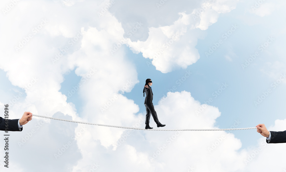 Business concept of risk support and assistance with man balancing on rope Business concept of risk support and assistance with man balancing on rope