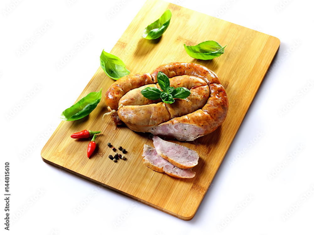 Close up view of roasted traditional homemade sausage with spices and herbs and spices spicy meat baked with herbs and spice on wooden cutting board.