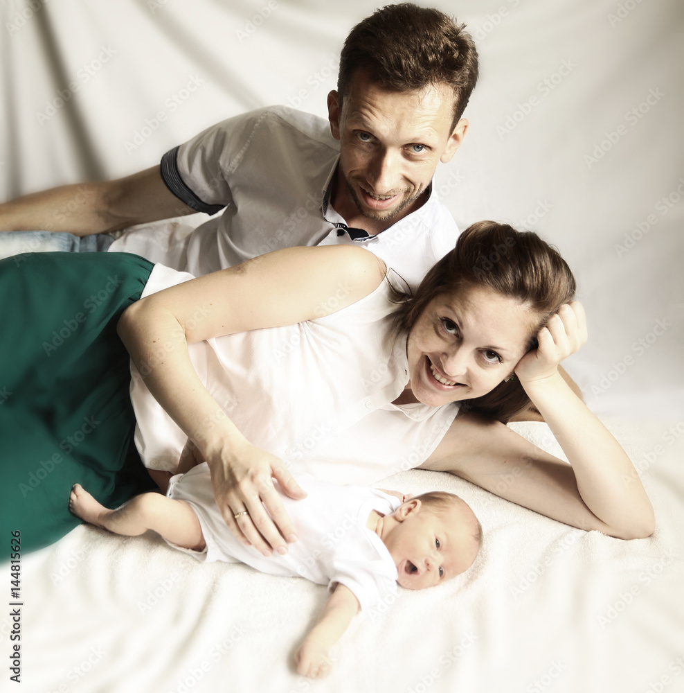 family happiness concept - happy mother and father lie side by s family happiness concept - happy mother and father lie side by s