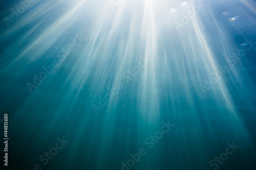 Sun rays in underwater. Ocean pattern in water. Ocean texture © artifirsov