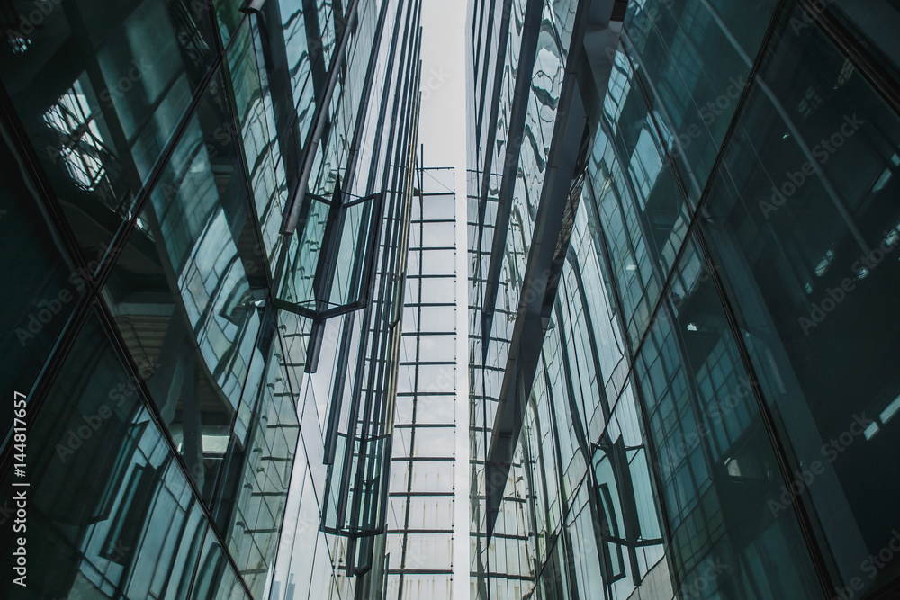 Modern black and dark blue glass skyscrapers background. Business construction concept of successful industrial solid. Glass steel architecture.