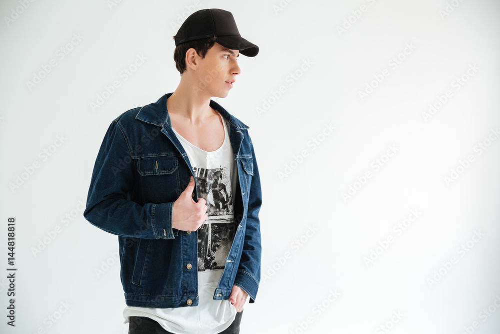 Side view of man in jeans jacket and cap Stock Photo | Adobe Stock