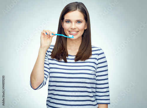 Fototapeta Naklejka Na Ścianę i Meble -  Smiling girl with brace brushing teeth.