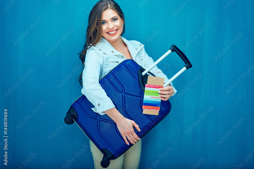 Smiling young woman holding suitcase, passport, ticket Smiling young woman holding suitcase, passport, ticket