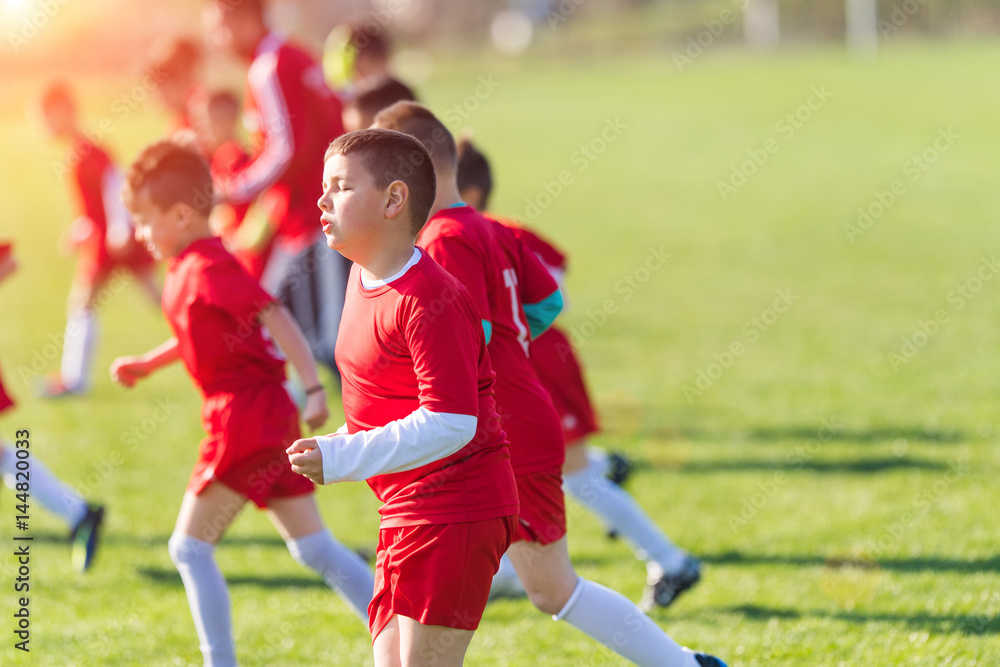 Obraz premium Kids soccer football - children players exercising before match on soccer field