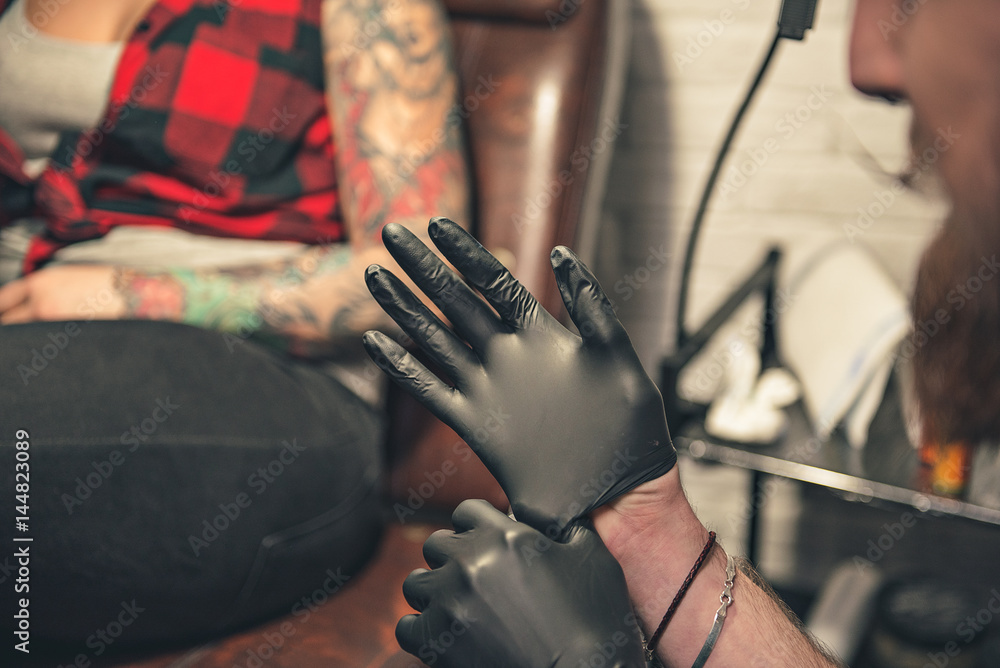 Man wearing gloves before creating picure on female body