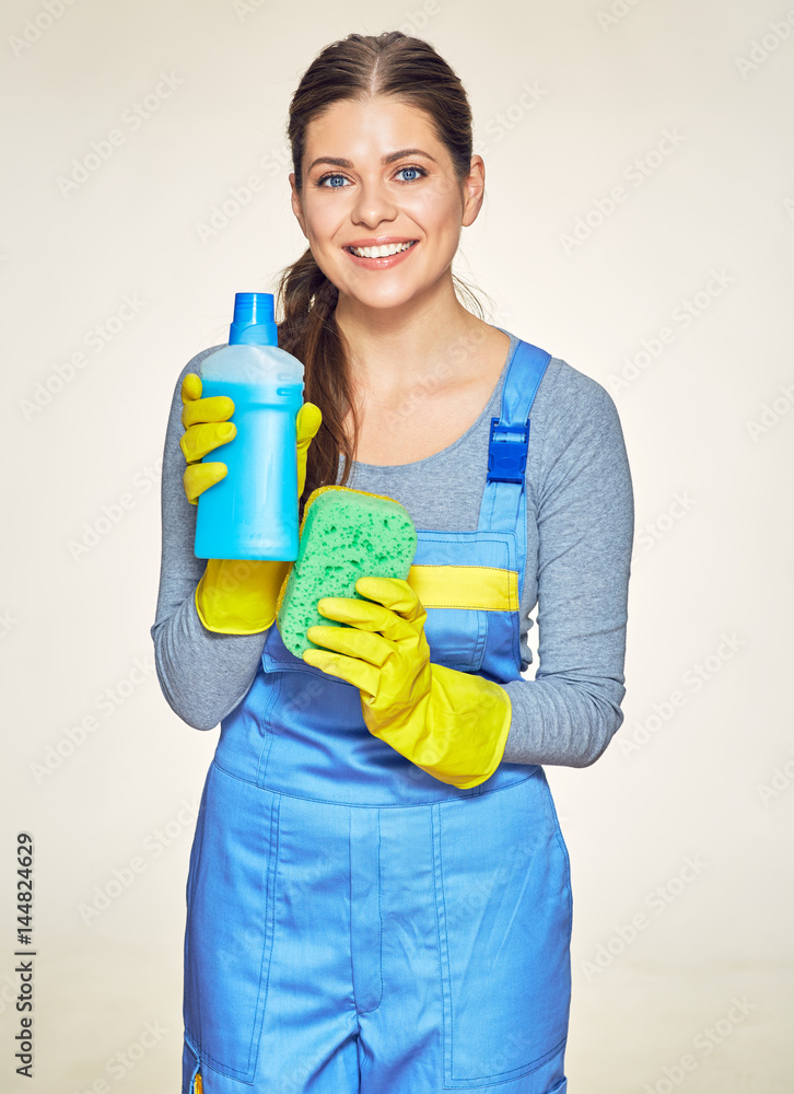 Woman wearing coveralls holding sleanser with sponge. Woman wearing coveralls holding sleanser with sponge.