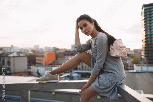 Obraz na płótnie Stylish woman sitting on roof and relaxing