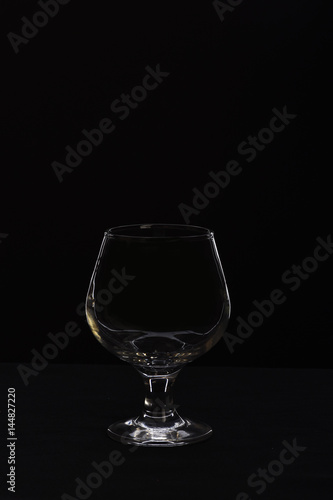 empty glass for cognac or whiskey isolated on black background