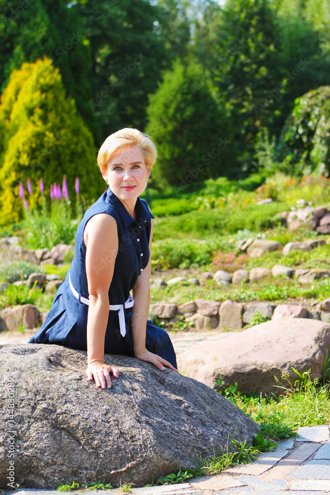 woman sitting on a big rock woman sitting on a big rock