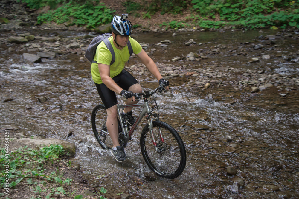 Young athlete crossing water barrier with bicycle