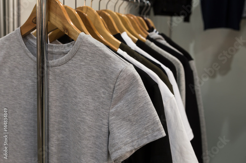 T-shirts black, gray and white monophonic hanging on holders