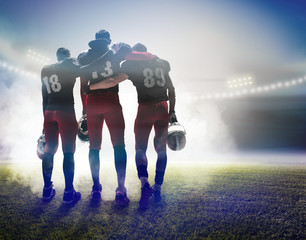 The three american football players on on stadium background