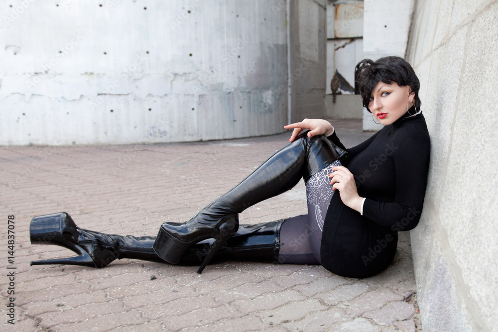 walking brunette short hair woman on the street wearing thigh high latex  platform boots and sweater Stock-Foto | Adobe Stock