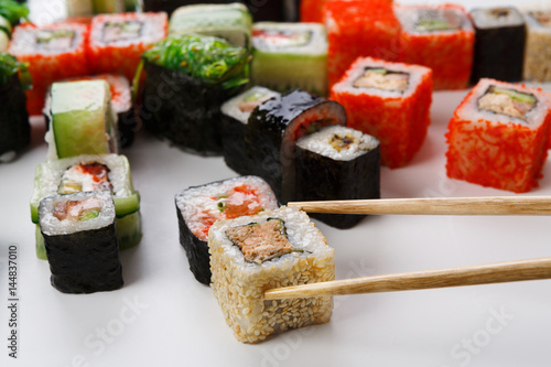Set of sushi, maki and rolls isolated closeup with chopsticks