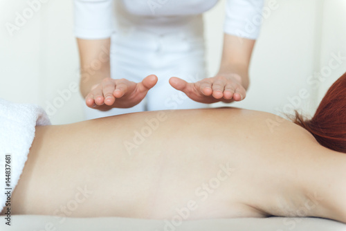 Beautiful young woman having massage in a spa salon.