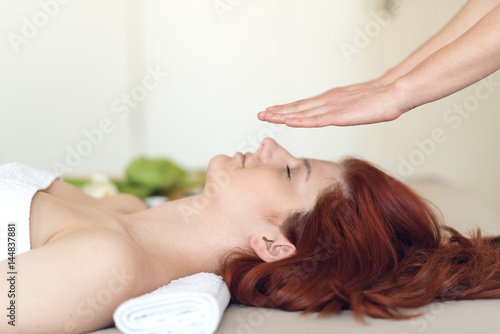 Young woman having her head massaged at a spa center