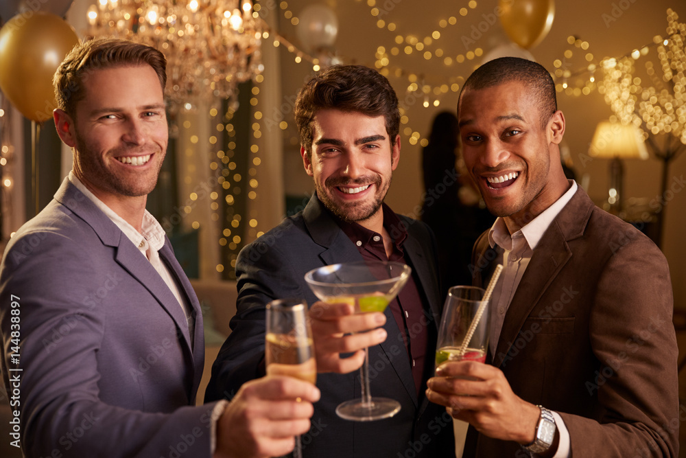 Male Friends Celebrating At Party Make Toast To Camera Male Friends Celebrating At Party Make Toast To Camera
