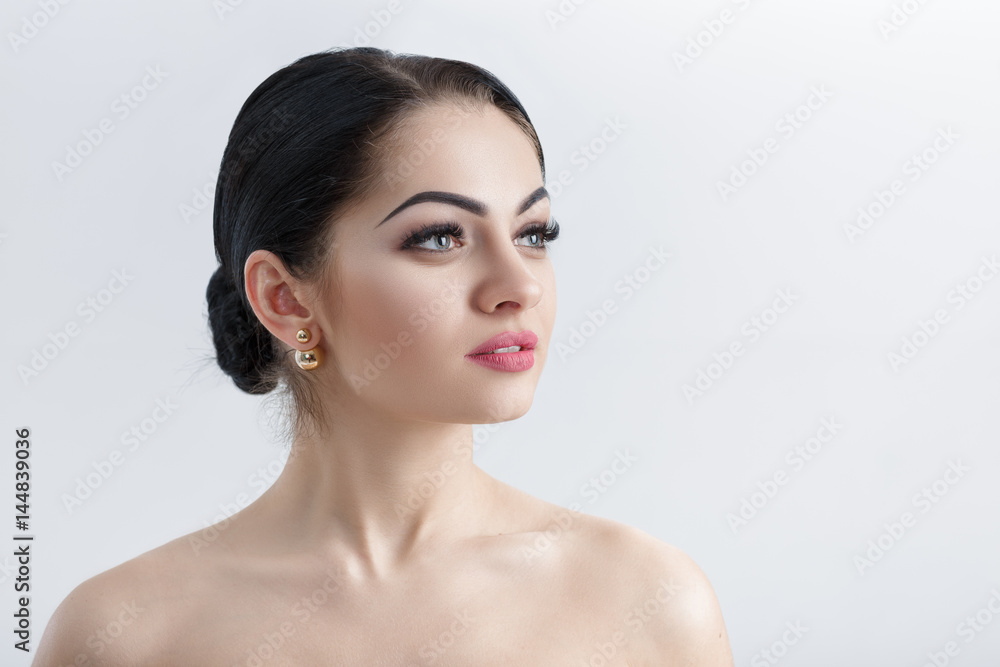 Front portrait of attractive young brunette woman on grey background closeup. girl with clean skin Front portrait of attractive young brunette woman on grey background closeup. girl with clean skin