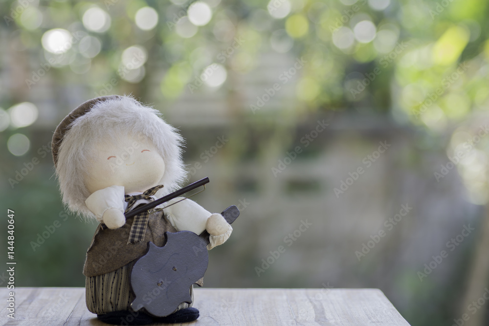Doll Violinist on wood and background bokeh. Doll Violinist on wood and background bokeh.