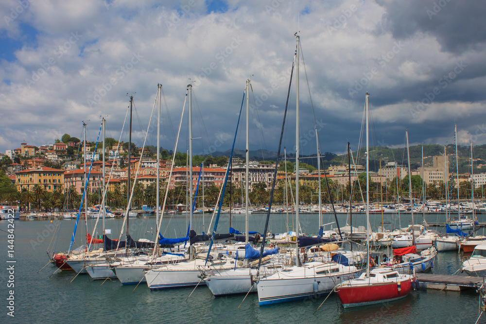 Yacht parking. Italian Riviera. Different yachts on the background of the sea and the city. The mountains Yacht parking. Italian Riviera. Different yachts on the background of the sea and the city. The mountains