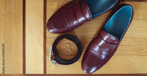 cherry men's shoes, belt and wedding rings in a box. groom's accessories at the wedding day