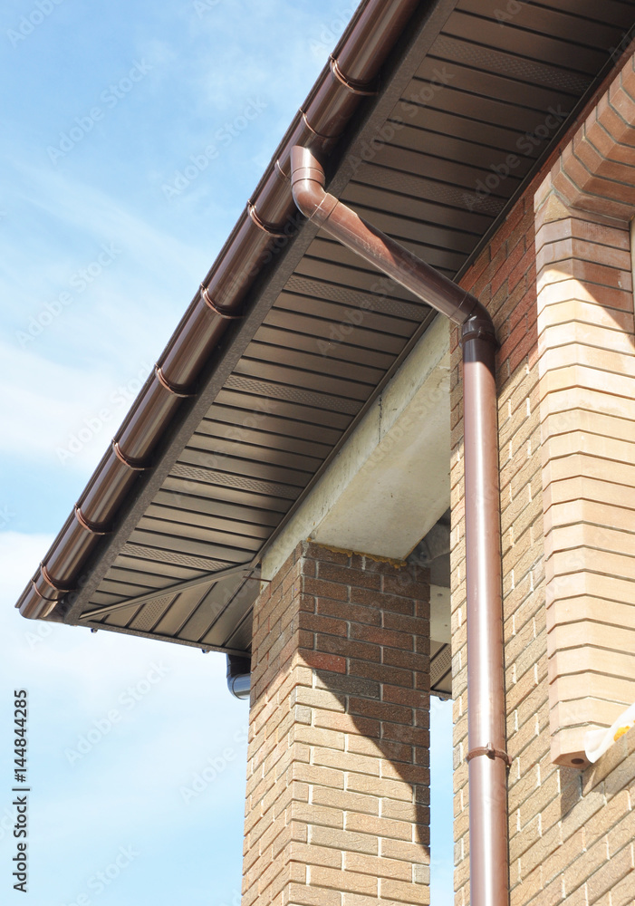 Rain Gutter Drain Pipe Downspout Installation on the Unfinished House