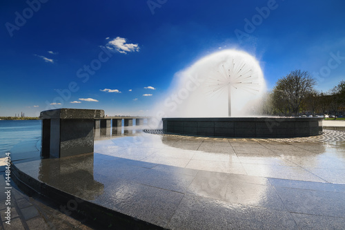 Beautiful fountain with reflection against the blue sky with clouds I photo