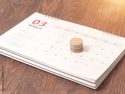 Saving money concept, money coin stack growing business with calenda.