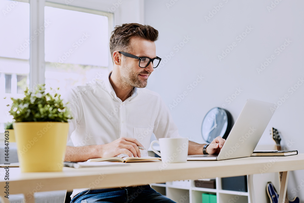 Happy man working on laptop from home office Happy man working on laptop from home office