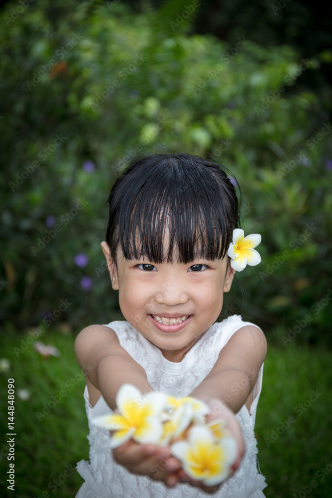 Asian Chinese little girl holding flowers in outdoor garden Asian Chinese little girl holding flowers in outdoor garden