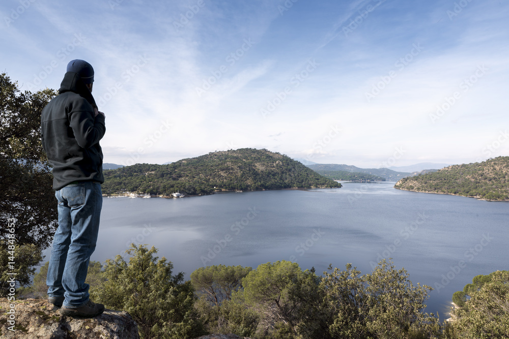 Man contemplates from the top the dam of San juan, Madrid, Spain