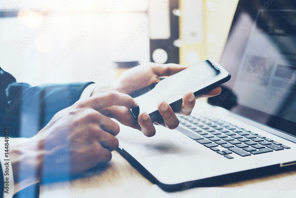 Businessman pointing finger on modern smartphone.Coworker working at sunny office at work place.Visual effects.Blurred background. Businessman pointing finger on modern smartphone.Coworker working at sunny office at work place.Visual effects.Blurred background.