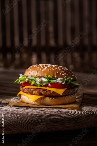 Tasty hamburger on kraft paper on a dark background