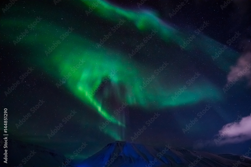 Fototapeta premium The polar Northern lights in the mountains of Svalbard, Longyearbyen, Spitsbergen, Norway wallpaper