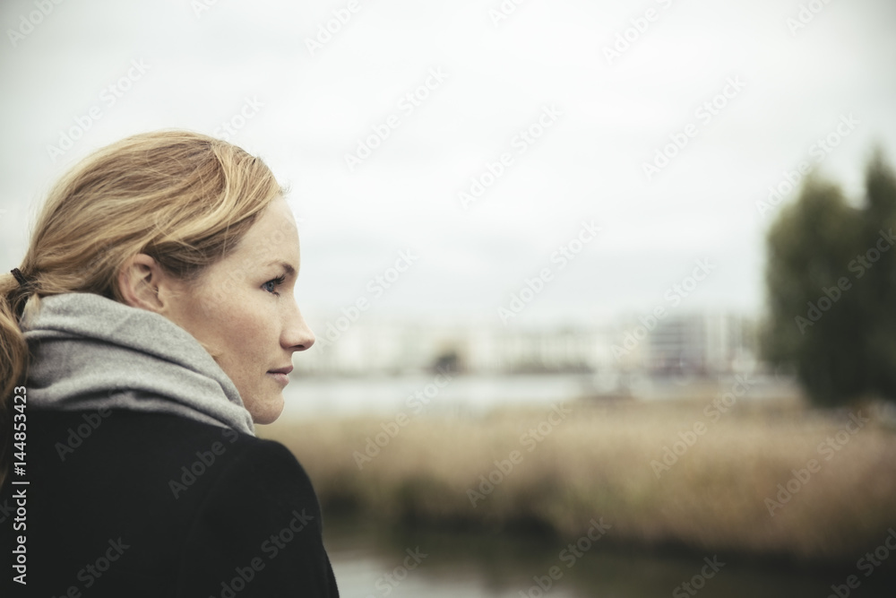 Side view of mid adult businesswoman looking away against sky Side view of mid adult businesswoman looking away against sky