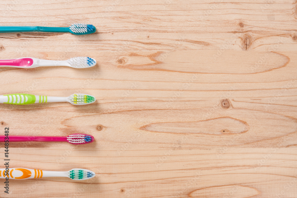 toothbrushes on the light wooden background with copy space for your text. Top view