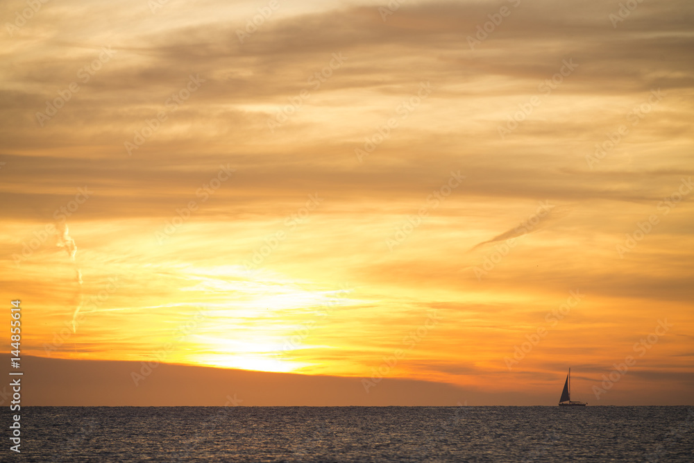 A photo of a sail boat in sunset