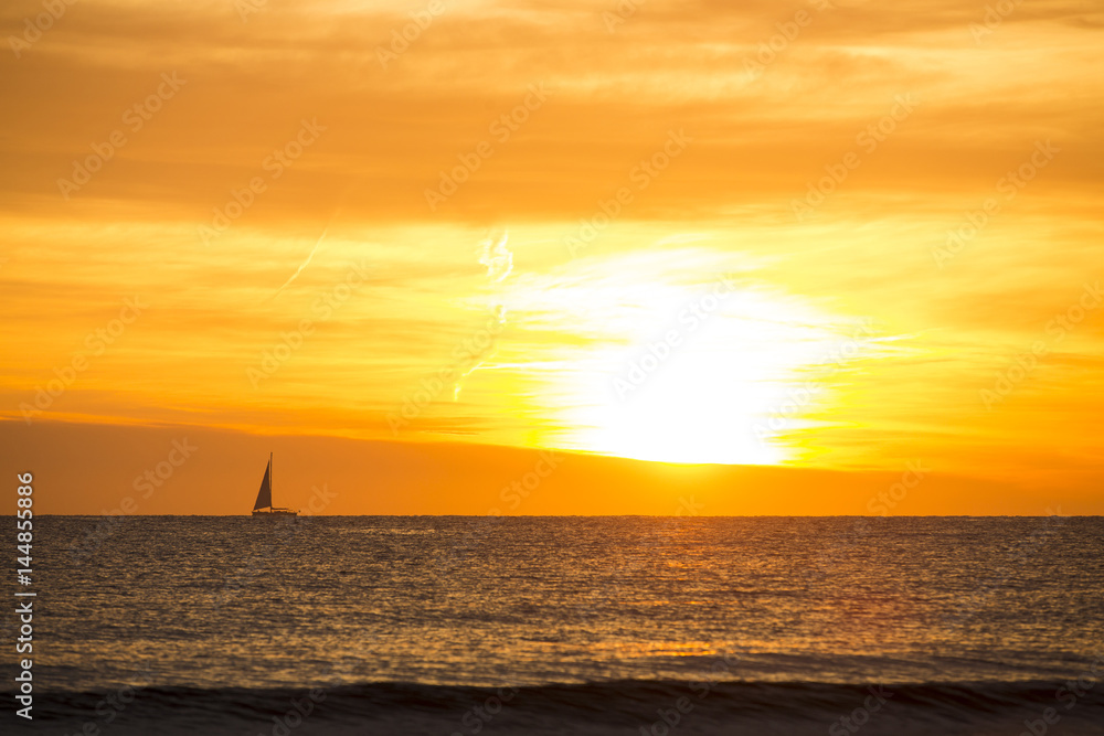 A photo of a sail boat in sunset A photo of a sail boat in sunset