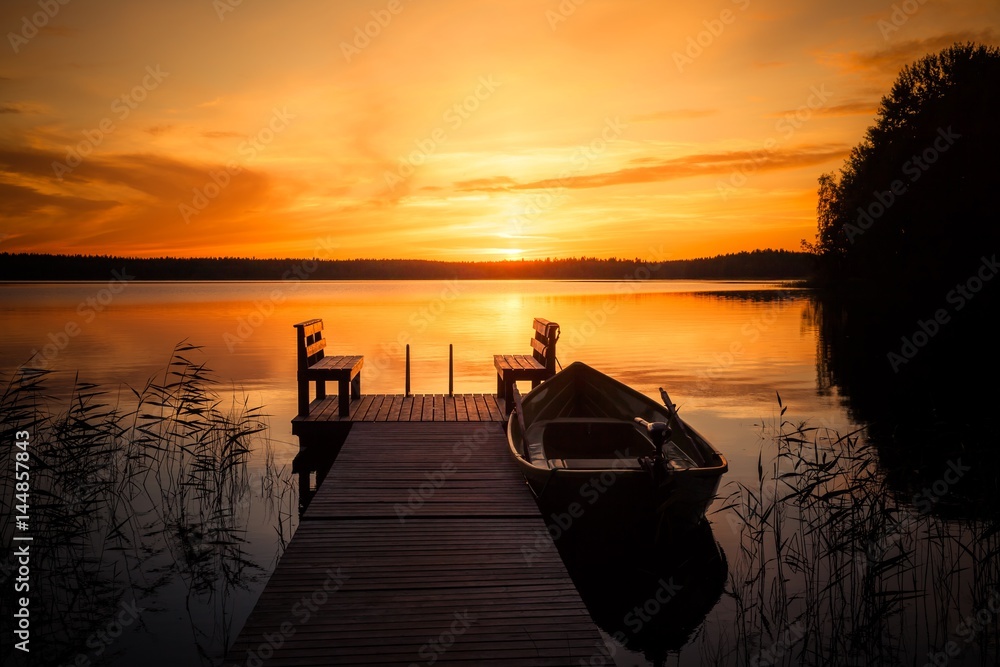Fototapeta premium Sunset over the fishing pier at the lake in Finland