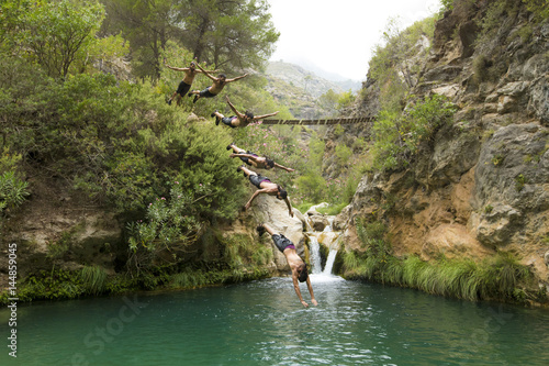 Young man jumping into river